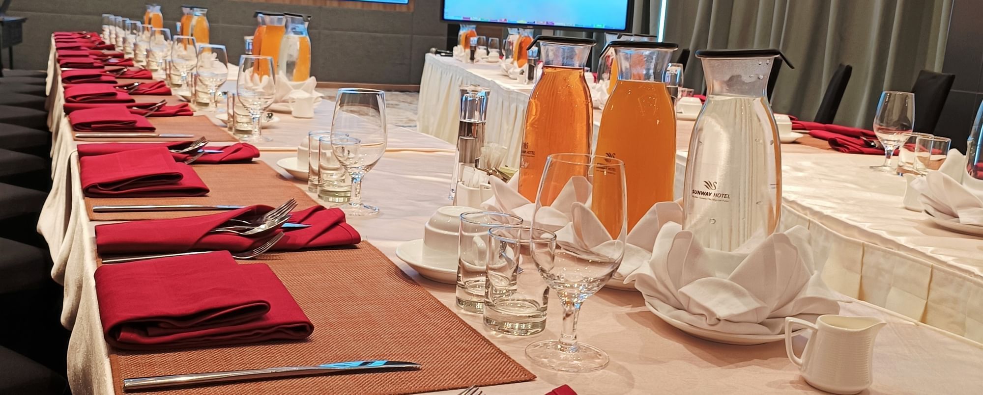 Long dining table arranged with vibrant red napkins at Sunway Hotel Big Box