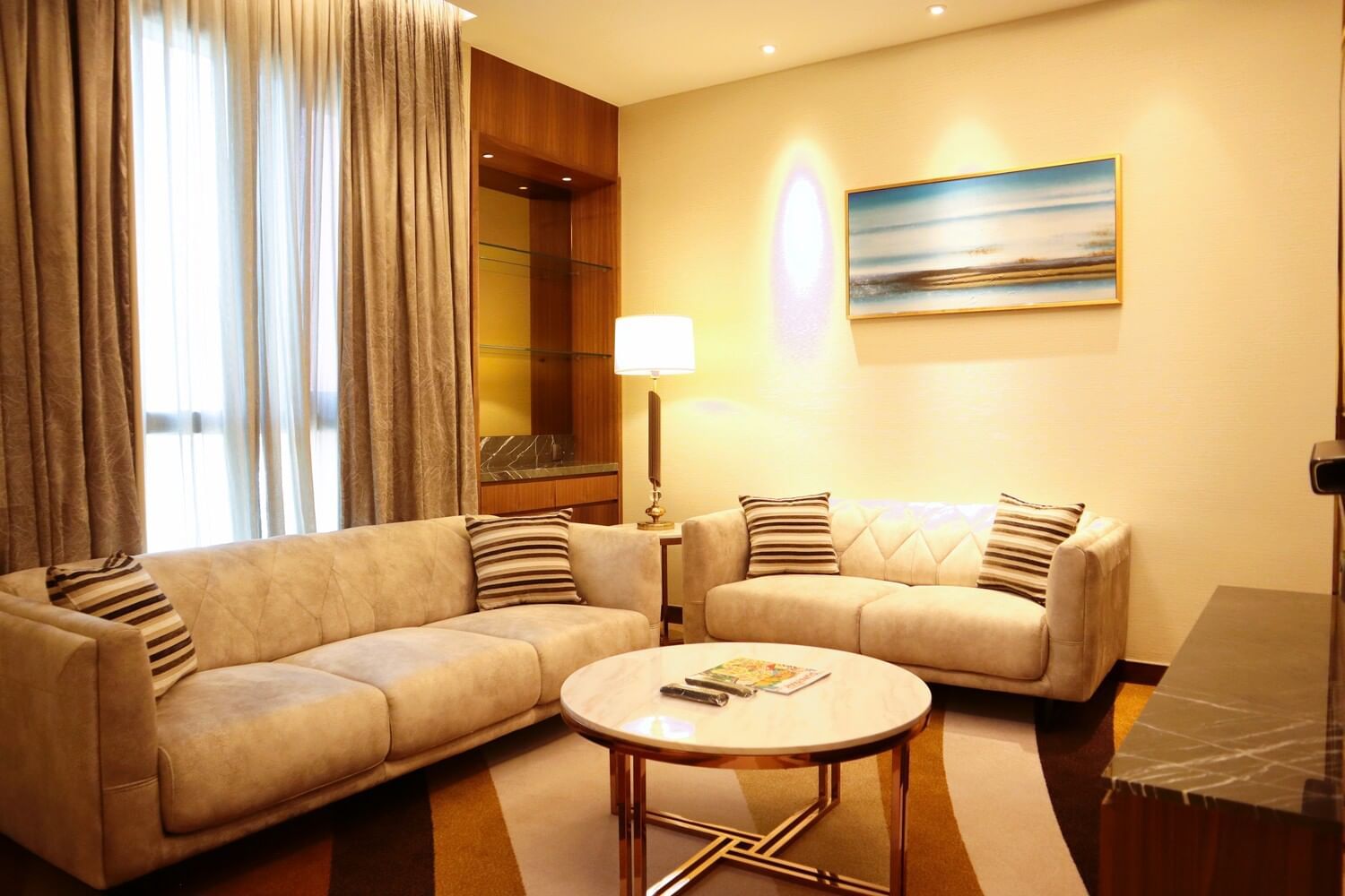 Luxury living room at Sunway Hotel Big Box, featuring a golden lamp and a striking mural wall