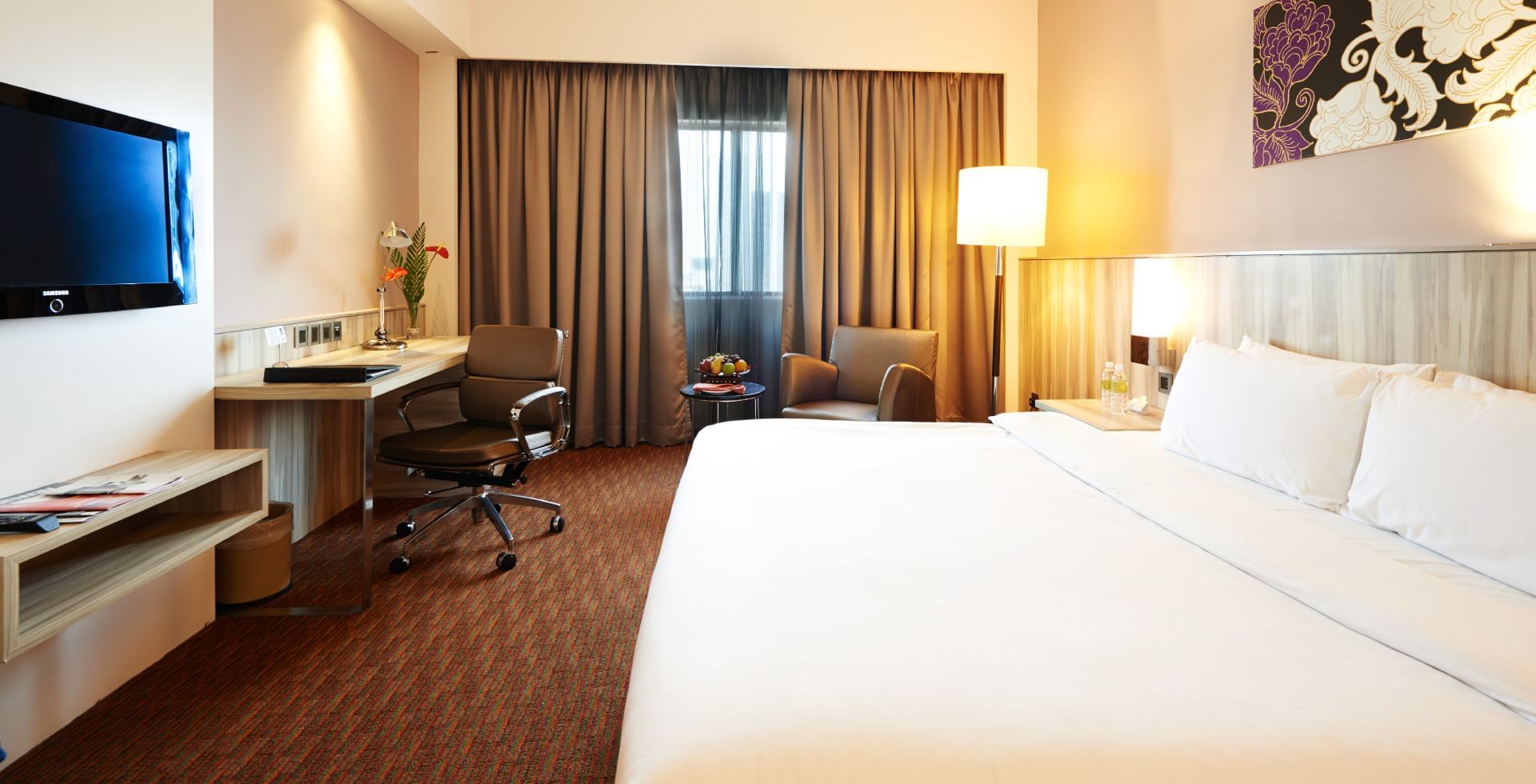 King bed with a work desk and a TV in Premier King Room at Sunway Hotel Seberang Jaya