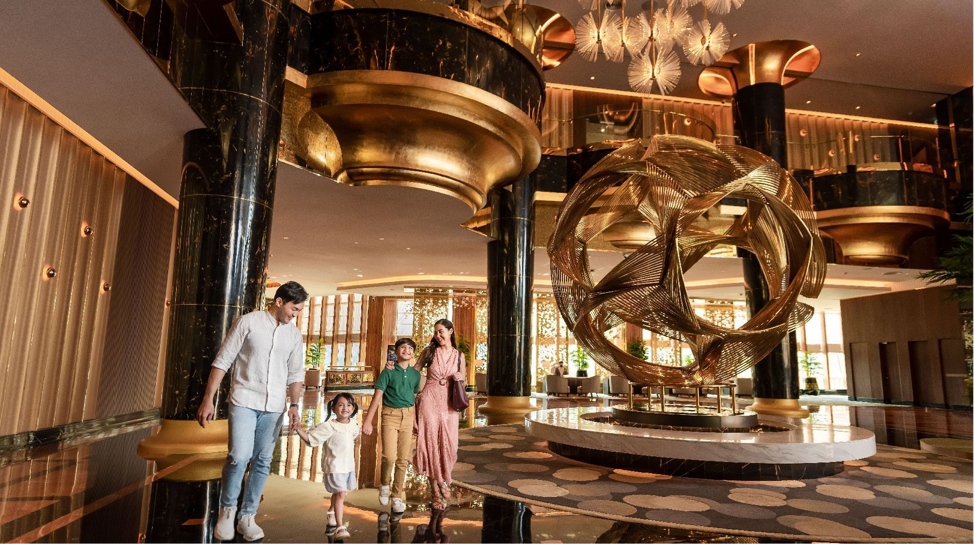 Family walking in the lobby with golden interior at Sunway Resort