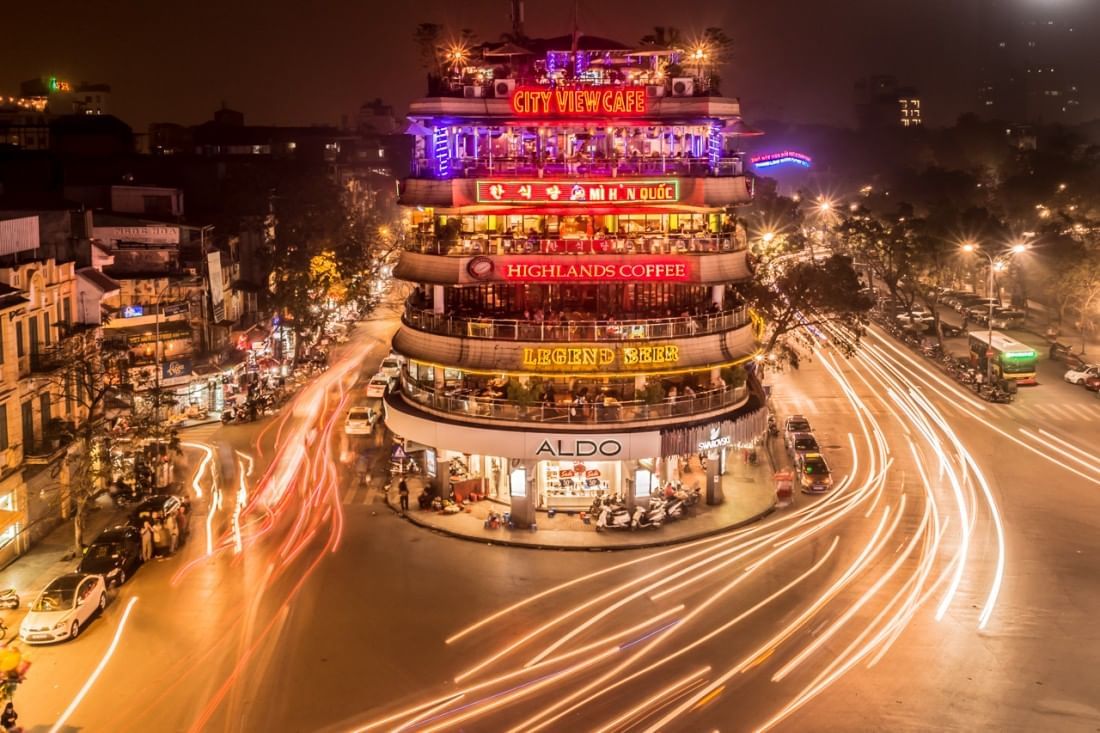 A bustling night street scene with buildings & light trails near Sunway Hotel Hanoi