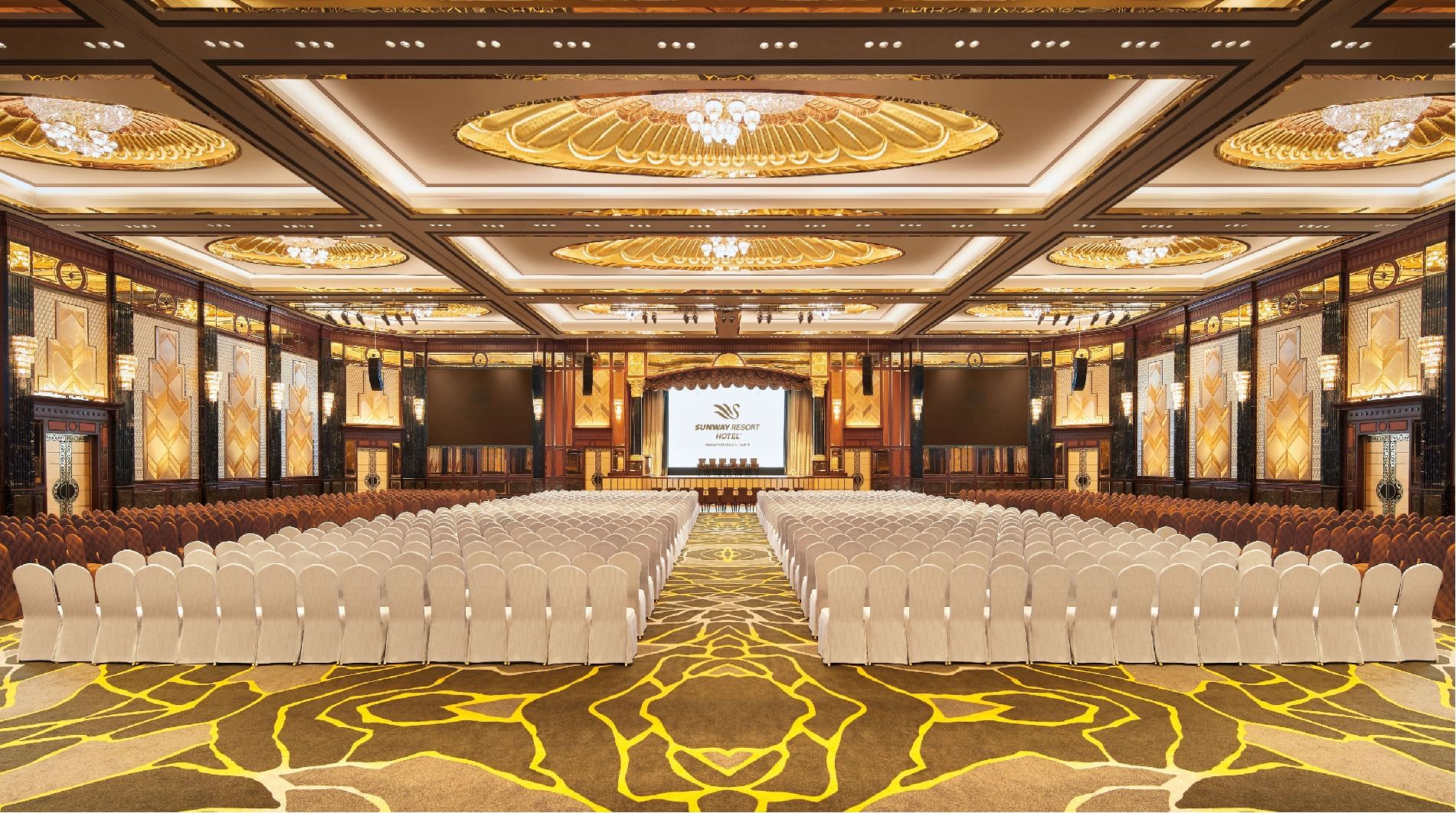 Grand Lagoon Ballroom with rows of chairs facing a stage & projector at Sunway Resort
