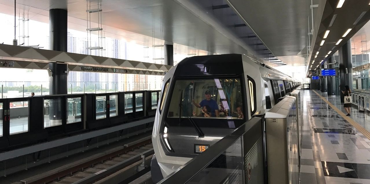 A modern train arriving at a Sentral MRT Station near Sunway Velocity Hotel