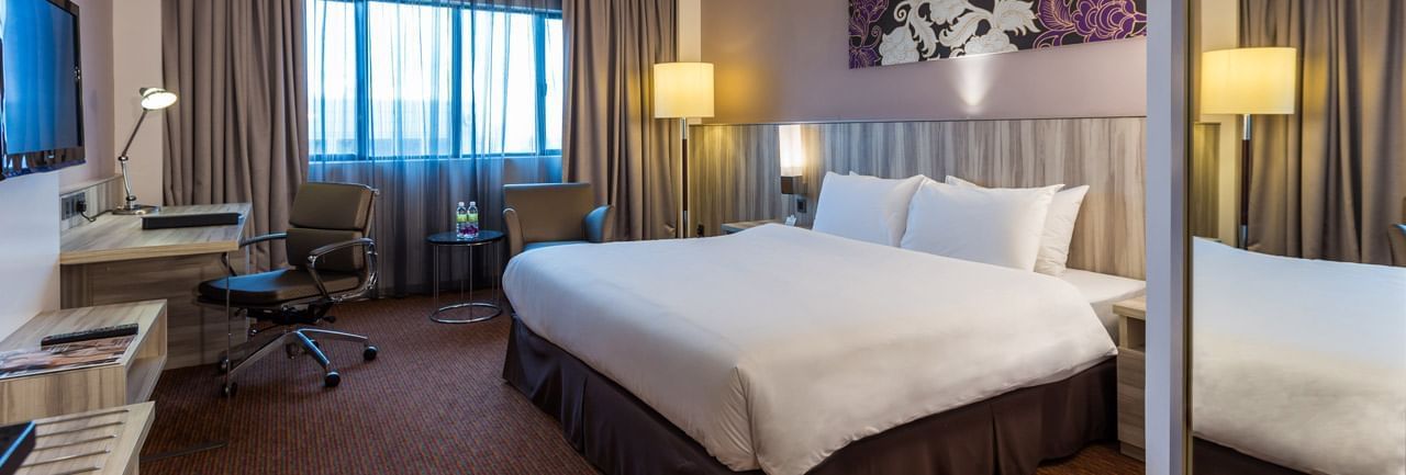 King bed with a work desk and a TV in Deluxe King Room at Sunway Hotel Seberang Jaya