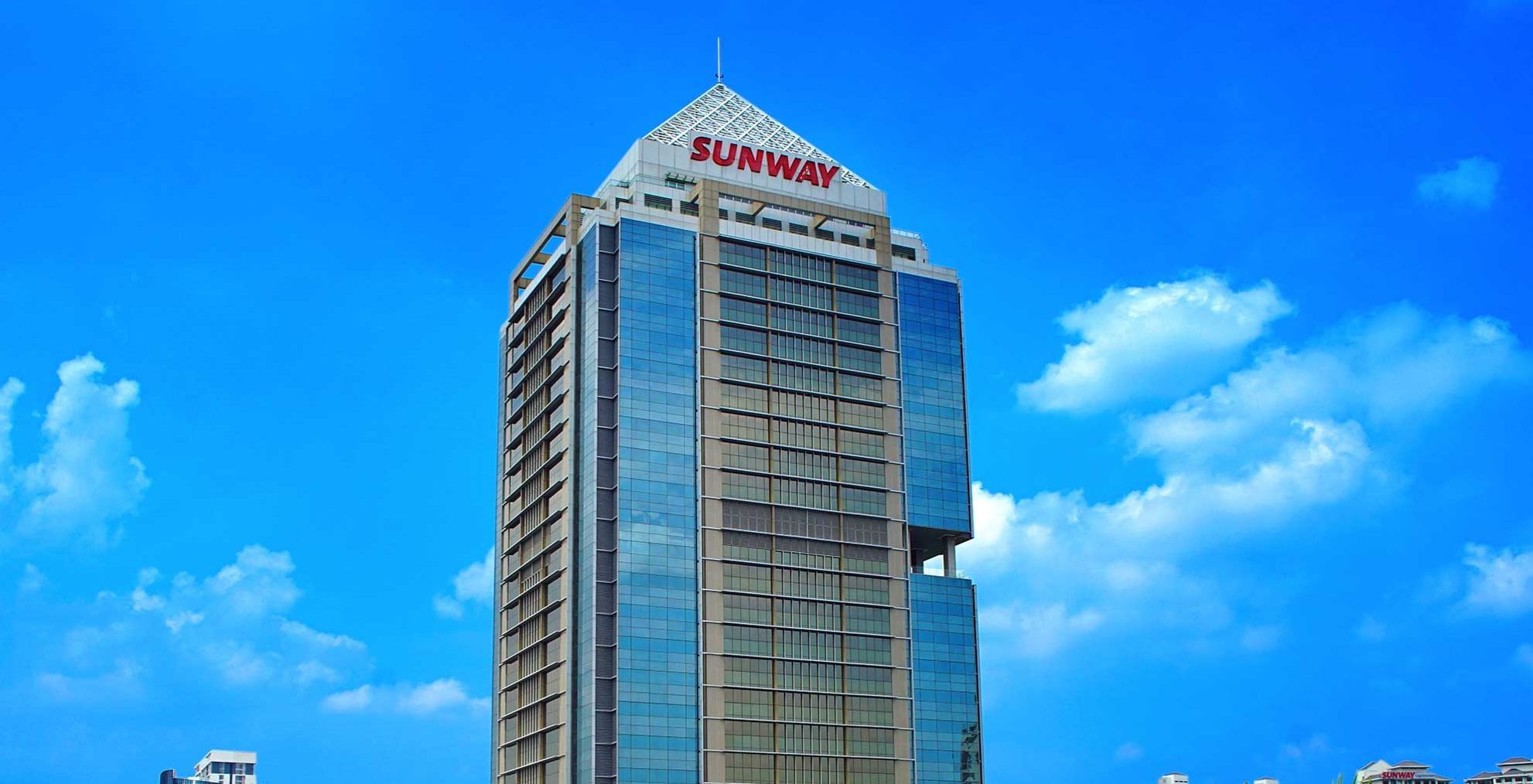 Skyscraper with hotel building's top against a blue sky at Sunway Hotels & Resorts