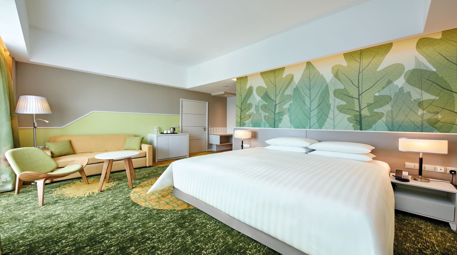 King-size bed with sitting area in Premier King room at Sunway Velocity Hotel