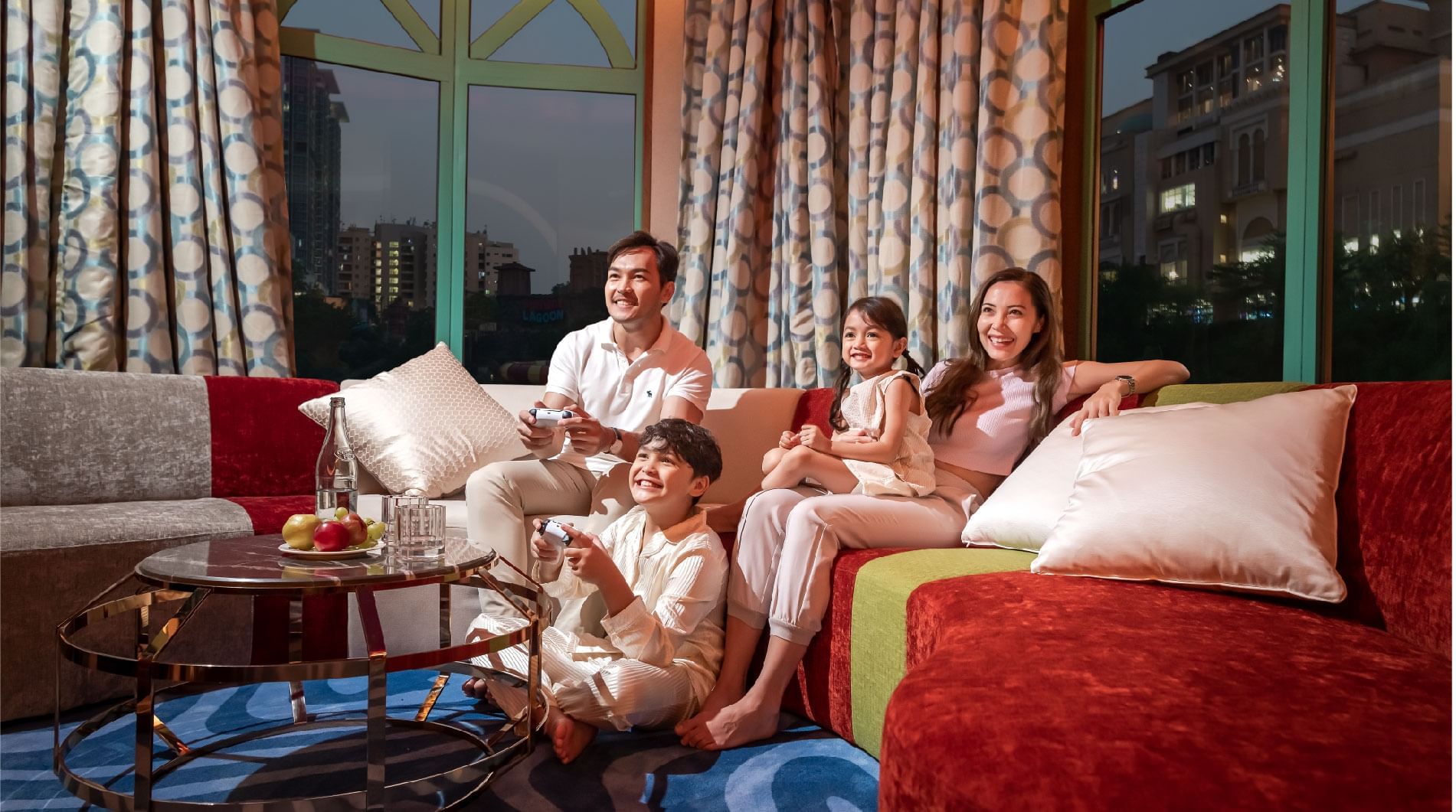 A family sitting on a sofa and enjoying a movie at Sunway Resort
