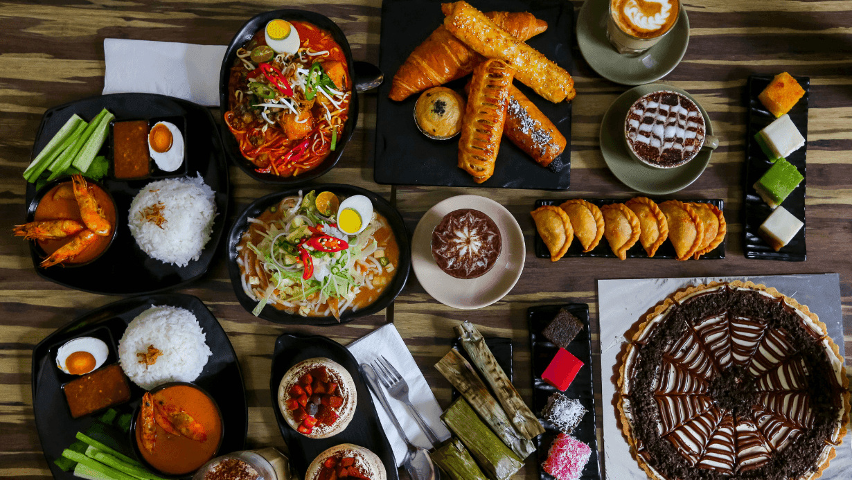 Asian dishes and desserts spread on a wooden table at Sunway Velocity Hotel
